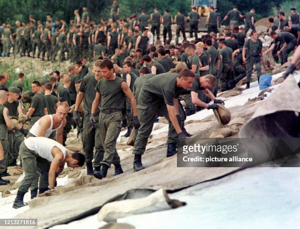 Mehr als 600 Soldaten versuchen am 30.7.1997, den Oderdeich bei Hohenwutzen mit Planen und Sandsäcken zu befestigen, weil die Deichkrone an der...