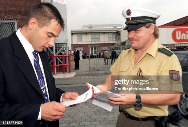 Ein Beamter der Hamburger Polizei verteilt am 2.8.1997 Flugblätter an die Besucher einer Werbeveranstaltung der Organisation "Titan". Auf den...