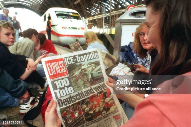 Schülerinnen und Schüler aus Frankfurt an der Oder lesen am 4.6.1998 vor einem wartenden ICE im Hauptbahnhof von Frankfurt am Main Zeitungen, in...