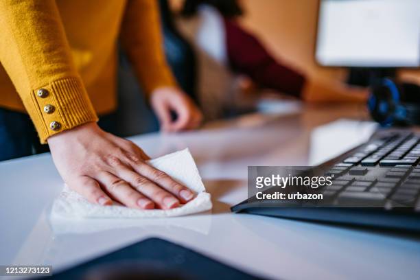 woman cleaning computer desk in office - rubbing stock pictures, royalty-free photos & images