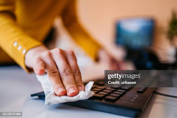 woman cleaning keyboard - unhygienic workplace stock pictures, royalty-free photos & images