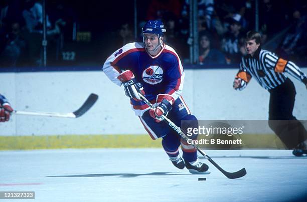 Dave Ellett of the Winnipeg Jets skates with the puck during an NHL game against the New York Islanders on November 1, 1986 at the Nassau Coliseum in...