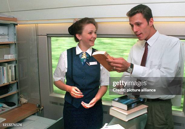 Zugbegleiterin Melanie Koss bietet am 20.8.1997 im ICE 573 von Frankfurt nach Darmstadt dem Fahrgast Philipp Hamann ein Buch an. Die Bahn AG und die...