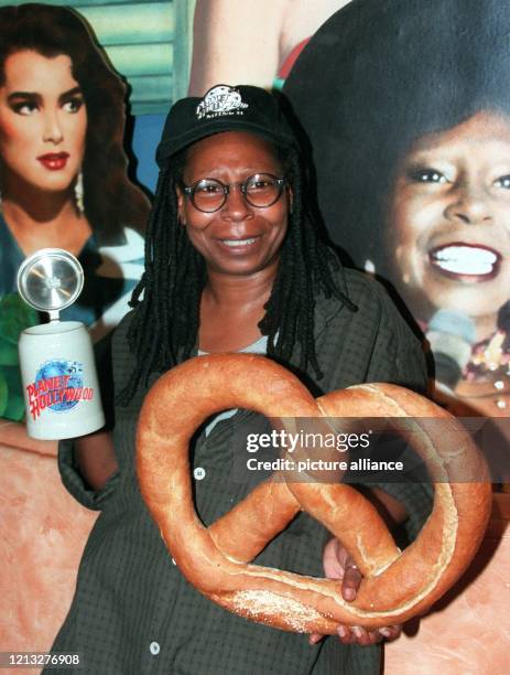 Mit bayerischer Brezel und einem Bierkrug läßt sich US-Filmstar Whoopi Goldberg am 25.8.1997 in Berlin fotografieren. Die Schauspielerin wollte die...