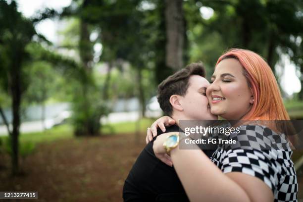 lesbian couple embracing at park - fat lesbian stock pictures, royalty-free photos & images