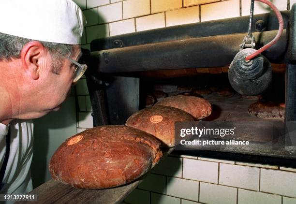 Bäcker Walter Rüffer holt mit einem Schieber am 24. Februar 1997 fertige Roggen-Sauerteigbrote aus dem Steinofen in der Backstube der Udenhausener...