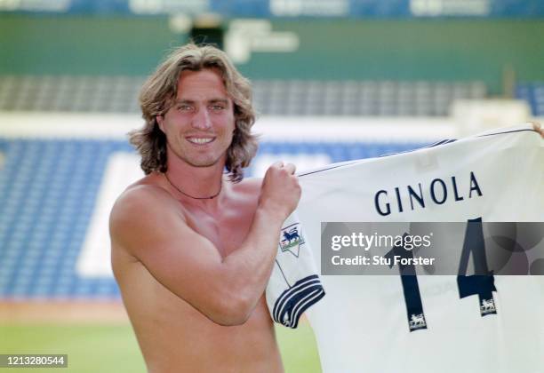 Bare chested David Ginola poses with his number 14 Spurs shirt at the press conference to herald his arrival at White Hart Lane from Newcastle United...