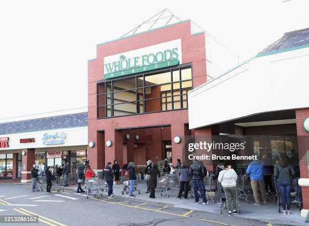 Customers wait for the opening of Whole Foods on March 18, 2020 in Jericho, New York. The World Health Organization declared COVID-19 a global...