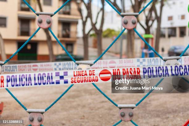 playground and park sealed by precaution.  concept of life under confinement   barrier tape in a playground, in a town in jaen, andalucia, spain, europe - police and criminal imagens e fotografias de stock