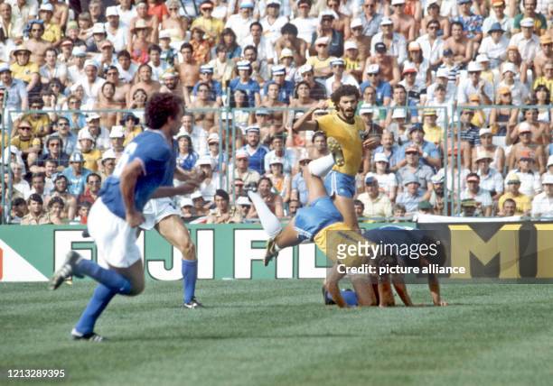 Der italienische Abwehrspieler Gaetano Scirea und der brasilianische Stürmer Eder kommen im Zweikampf zu Fall, Eders Teamgefährte Socrates und...