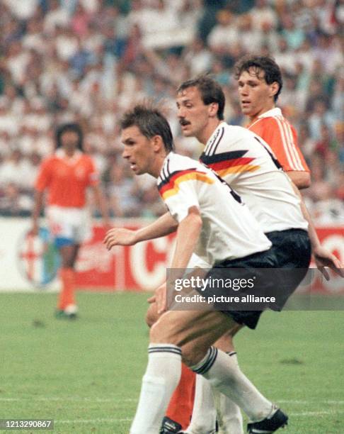 Sie starren gebannt auf den Ball: Die deutschen Verteidiger Klaus Augenthaler und Jürgen Kohler sowie der niederländische Torjäger Marco van Basten ....