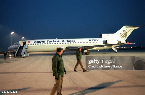 Zwei Polizisten schauen am 9.3.1996 auf dem Münchner Flughafen zur Boeing 724 der türkisch-zyprischen Fluggesellschaft KTHY hinüber, nachdem kurz...
