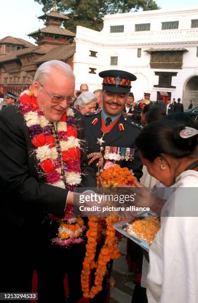 Blüten streut diese Frau am zur Begrüßung von Bundespräsident Roman Herzog in Kathmandu in dessen geöffnete Hände. Um den Hals trägt der...