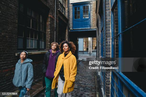 three hip friends walking together in the city - shoreditch stock pictures, royalty-free photos & images