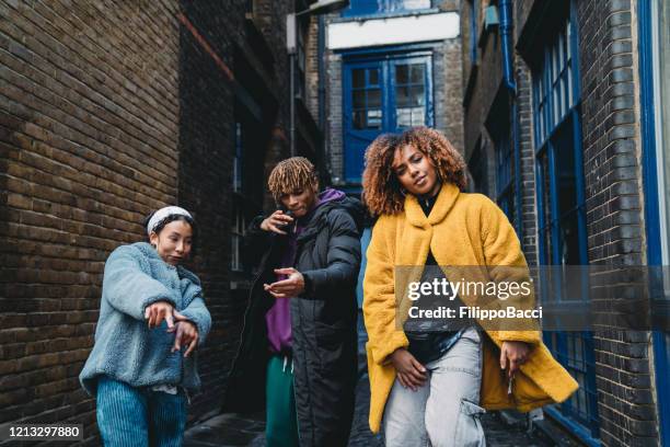 tres amigos de moda bailando juntos al aire libre en la ciudad - hip hop dance fotografías e imágenes de stock