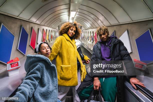 tres amigos en escaleras mecánicas en el metro - underground london fotografías e imágenes de stock