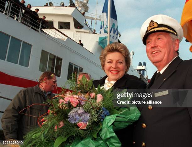 Strahlend und mit einem riesigen Blumenstrauß im Arm, steht Schauspielerin Marie-Luise Marjan an der Seite von Kapitän Walentin Sidorow vor dem...