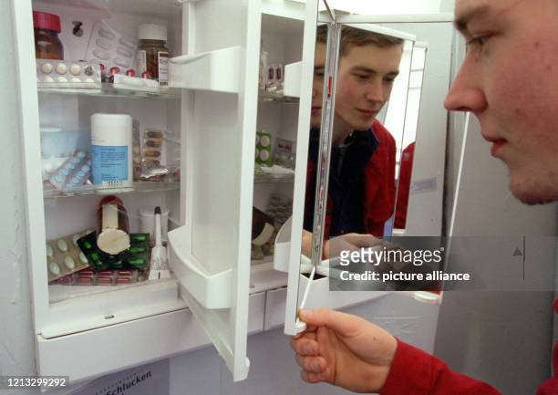 Ausstellungsbesucher Sven Harmsen schaut am 17.4.1997 in einen Schrank voller Medikamente bei der Wanderausstellung "SehnSucht" der Bundeszentrale...