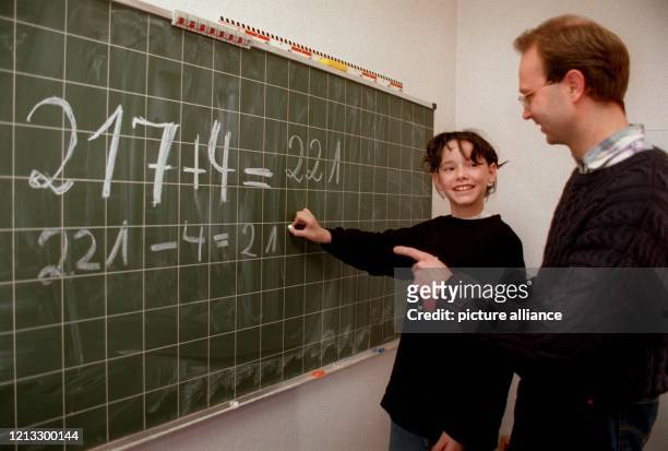 Im Zentrum zur Therapie der Rechenschwäche steht Yasmin neben ihrem Lehrer Josef Kokott vor einer Tafel mit Mathematikaufgaben. Rechenschwache Jungen...