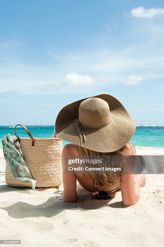 Woman lying on sandy beach, Mustique, Grenadine Islands