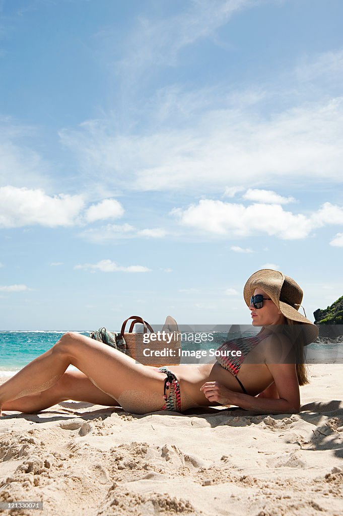 Woman lying on sandy beach, Mustique, Grenadine Islands