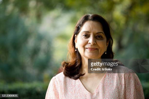 hogere vrouw die camera bekijkt - indian subcontinent stockfoto's en -beelden