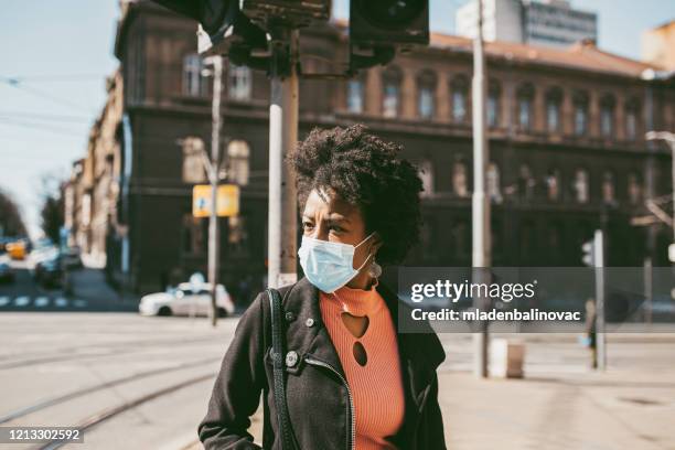 porträt der jungen frau mit maske auf der straße. - pollution masks stock-fotos und bilder