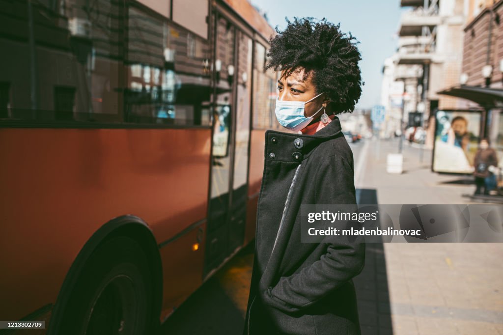 Portret van jonge vrouw met masker op de straat.