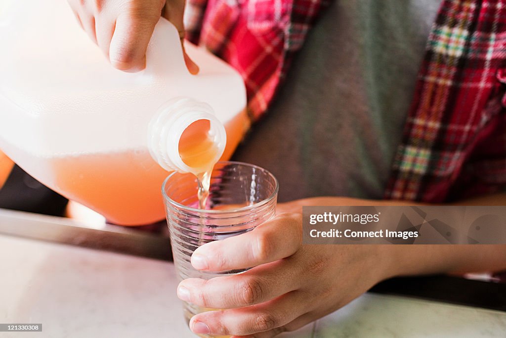 Boy pouring glass of juice