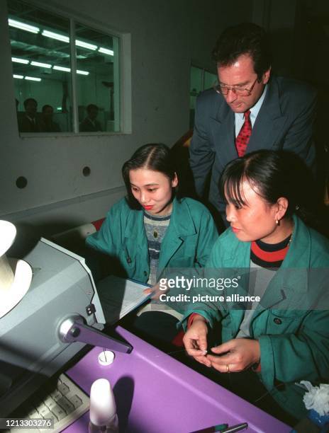 Bundesaußenminister Klaus Kinkel schaut zwei Arbeiterinnen über die Schulter, die am in der Siemens-Glasfaserkabelfabrik von Chengdu Kabel prüfen....