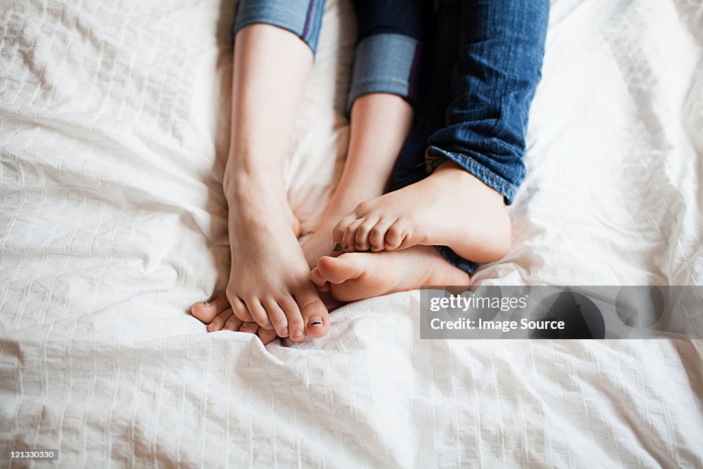 Two teenage girls playing footsie