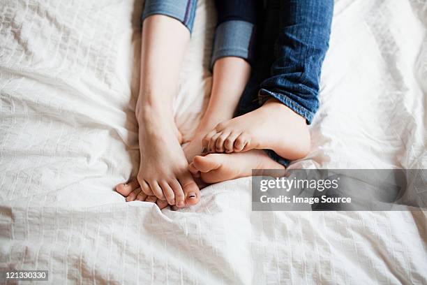 two teenage girls playing footsie - playing footsie stock-fotos und bilder