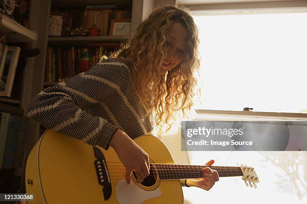 teenage girl playing guitar - playing guitar stock pictures, royalty-free photos & images