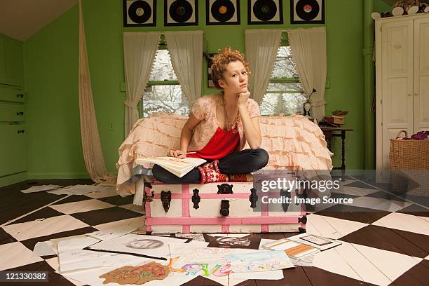 teenage girl sitting on ottoman with drawings on bedroom floor - chatham new york state stock pictures, royalty-free photos & images