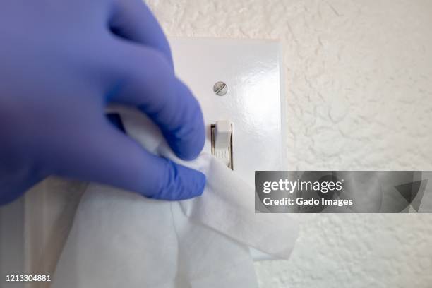 covid-19 sanitizing surfaces - office light switch hand stock pictures, royalty-free photos & images