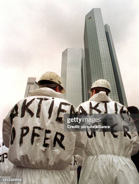 Als "Aktienopfer" bezeichnen sich Stahlarbeiter auf ihren Overalls auf der Protestkundgebung vor den Hochhaustürmen der Deutschen Bank am 25.3.1997...