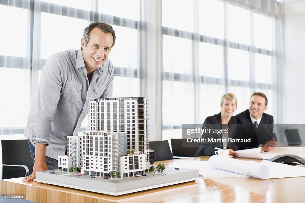 Architects in conference room with building model