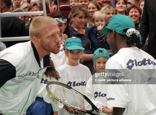 Nach einem Trainingsspiel mit Kindern und Jugendlichen verabschiedet sich Boris Becker von einer dunkelhäutigen Teilnehmerin mit Kußmund. Auf...