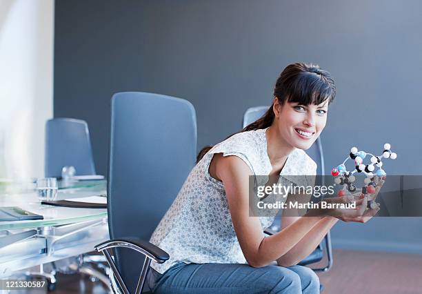 businesswoman holding molecule model in conference room - female model stock pictures, royalty-free photos & images