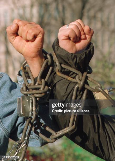 Mit schweren Eisenketten aneinandergebunden, recken zwei Bergarbeiter am 10.3.1997 vor der Bonner FDP-Parteizentrale ihre Fäuste empor. Aus Protest...