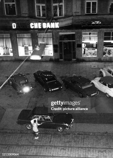 Der Kassierer der Bank bringt eine der weiblichen Geiseln zu dem Fluchtauto. Ein Banküberfall mit Geiselnahme Anfang August 1971 hat zwei Todesopfer...