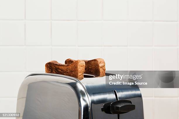 dos rodajas de pan tostado en tostadora - toaster fotografías e imágenes de stock