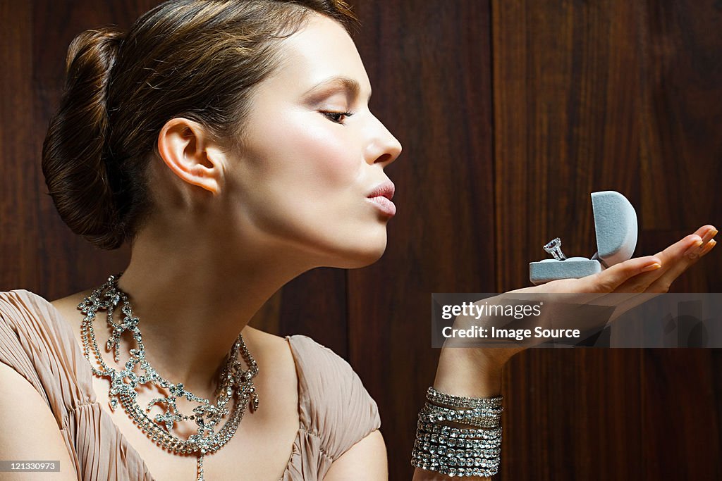 Young woman looking at engagement ring in box