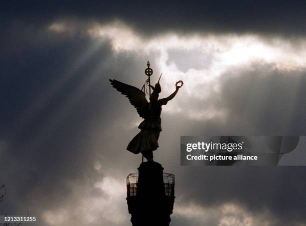 Lichtstreifen durchbrechen am 20.2.1997 die sturmgepeitschten Wolkenfelder in Berlin und umgeben bedrohlich die Göttin Nike auf der Siegessäule in...