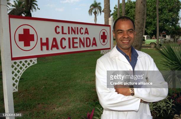 Charles Huber vor dem Schild zu "seiner" Klinik am 17.2.1997 in Puerto Plata. In der Dominikanischen Republik steht er zur Zeit an der Seite von...