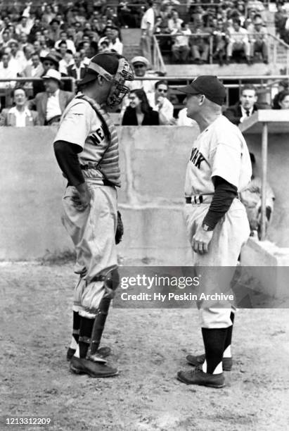Catcher Yogi Berra of the New York Yankees talks to his coach Charlie Dressen before batting during an MLB Spring Training game against the Brooklyn...