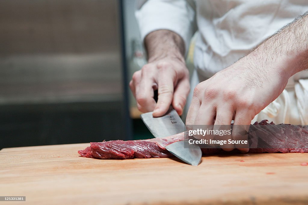 Butcher preparing beef tenderloin