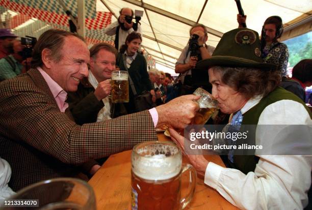 Aus meiner Maß schmeckt's besser - am "Stammtisch" im Bierzelt läßt Prinz Sadruddin Aga Khan am Prinzessin Hella von Bayern von seinem Bier kosten....