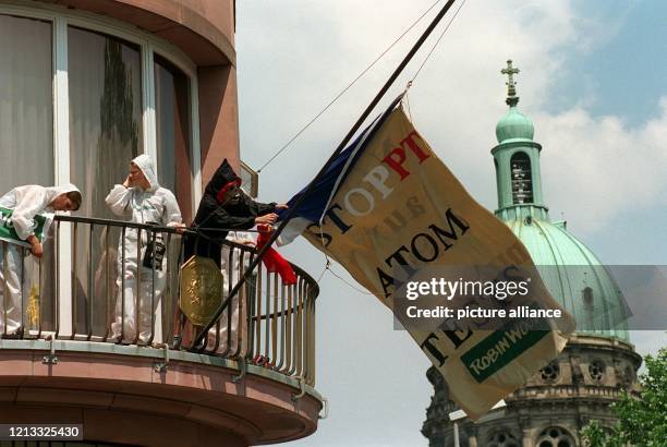 Verkleidete Mitglieder der Umweltschutzorganisation Robin Wood befestigen vom Balkon des französischen Konsulats aus am Fahnenmast ein Transparent.In...