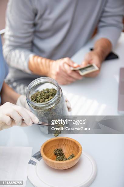 weighing cannabis at cannabis store - stock photo - cannabis dispensary stock pictures, royalty-free photos & images